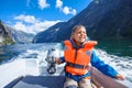 Portrait of boy close up driving the motorboat, Norway. He is enjoying the moment. Royalty Free Stock Photo