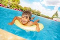 Happy boy floating on swim tube in swimming pool Royalty Free Stock Photo