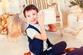 Portrait of happy boy with gift box, behind the decorated Christmas tree, the light give a cozy atmosphere. Royalty Free Stock Photo