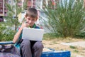 Portrait of a happy boy, holding a laptop, raised his thumb up. The boy likes to study on a laptop, do homework Royalty Free Stock Photo