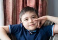 Portrait Happy boy sitting on sofa looking at camera with smiling face, Positive Child resting in living room with light shining Royalty Free Stock Photo