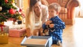 Portrait of happy little boy sitting under Christmas tree with open gift box Royalty Free Stock Photo