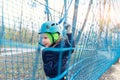 Portrait happy brave courage little toddler child boy wear safety equipment helmet enjoy passing obstacle course forest