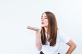 Portrait of happy brunette girl in white T-shirt sending air kiss isolated on white background. Caucasian young woman gesticulatin Royalty Free Stock Photo