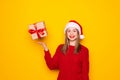 Portrait of happy brunette young woman in santa hat standing throwing gift boxes in air or catching presents, christmas shopping Royalty Free Stock Photo