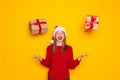 Portrait of happy brunette young woman in santa hat standing throwing gift boxes in air or catching presents, christmas shopping Royalty Free Stock Photo