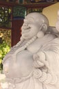 Portrait Happy Buddha stone statue is symbol of abundance and happiness that it is situated in Chainese temple.