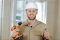 portrait happy builder handyman with electric drill indoors Royalty Free Stock Photo