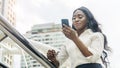 Portrait of happy business african woman uses smartphone