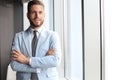 Portrait of happy businessman with arms crossed standing in office Royalty Free Stock Photo