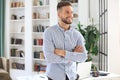 Portrait of happy businessman with arms crossed standing in office Royalty Free Stock Photo