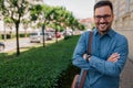 Portrait of happy businessman carrying bag standing with arms crossed in the city Royalty Free Stock Photo