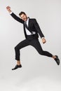 Portrait of a happy businessman jumping in air against isolated white background. Royalty Free Stock Photo