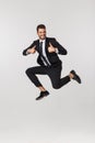 Portrait of a happy businessman jumping in air against isolated white background. Royalty Free Stock Photo