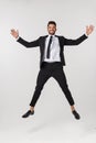 Portrait of a happy businessman jumping in air against isolated white background. Royalty Free Stock Photo