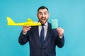 Portrait of happy businessman in official style suit holding paper plane and passport, dreaming of vacation abroad, trip around Royalty Free Stock Photo
