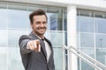 Portrait of happy businessman pointing at you outside office building Royalty Free Stock Photo