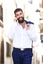 Happy businessman walking in city and talking on smart phone Royalty Free Stock Photo