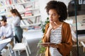 Portrait of businesswoman holding tablet in office and colleagues discussing in background Royalty Free Stock Photo