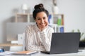 Portrait of happy businesswoman sitting at her workplace in front of laptop and smiling at camera at modern office Royalty Free Stock Photo