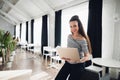 Portrait of happy businesswoman smiling for camera while working on laptop computer in office interior or cafe. Business Royalty Free Stock Photo