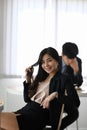 Happy businesswoman smiling to camera and sitting with her colleague in office. Royalty Free Stock Photo