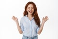 Portrait of happy candid redhead girl laughing, smiling with white teeth, spread hands sideways carefree and chuckle