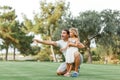 Portrait of a happy caring father teaching his small pretty daughter how launching a toy plane in a green park  smiling Royalty Free Stock Photo