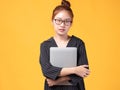 Portrait of happy casual Asian girl student with laptop isolated on yellow background. Back to school and learning concept Royalty Free Stock Photo