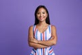 Portrait of a happy casual asian woman standing isolated over violet background,