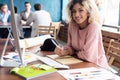 Portrait of a happy casual businesswoman sitting at her workplace in office Royalty Free Stock Photo