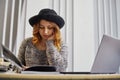 Portrait of happy casual businesswoman in sweater sitting at her workplace in the office. She is reviewing the document Royalty Free Stock Photo