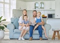 Portrait of a happy caucasian family of four reading a story and fairytale from books while relaxing together on the Royalty Free Stock Photo