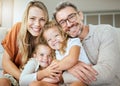 Portrait of a happy Caucasian family of four relaxing in the living room at home. Loving smiling family being Royalty Free Stock Photo