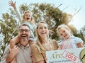 Portrait of happy caucasian family holding a sold sign while relocating and moving into a new house. Smiling parents and Royalty Free Stock Photo