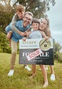 Portrait of happy caucasian family holding a sold sign while relocating and moving into a new house. Smiling parents and Royalty Free Stock Photo