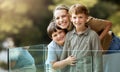 Portrait of a happy caucasian family of three enjoying the view from a balcony at home. Smiling single parent bonding Royalty Free Stock Photo