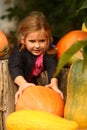 Portrait of happy caucasian girl holding autumn harvest of ripe pumpkins in the vegetable garden Royalty Free Stock Photo