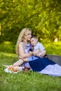 Portrait of Happy Caucasian Mother With Her Little Kid. Posing with Basket Full of Bread Rings Outdoors Royalty Free Stock Photo