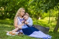 Portrait of Happy Caucasian Mother With Her Upset Little Kid. Posing with Basket Full of Bread Rings Outdoors Royalty Free Stock Photo