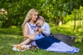 Portrait of Happy Caucasian Mother With Her Upset Little Kid. Posing with Basket Full of Bread Rings Outdoors Royalty Free Stock Photo