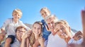 Portrait of happy caucasian multi-generation family standing together and taking a selfie outdoors against a blue sky Royalty Free Stock Photo