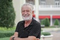 Portrait of happy Caucasian senior kind man with winkles and white beard mustache hairs. Old man is smiling