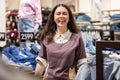Portrait of happy Caucasian smiling woman posing in clothing store. Concept of sales and seasonal discounts Royalty Free Stock Photo