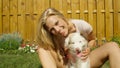 PORTRAIT: Happy Caucasian woman pets fluffy little dog and looks at the camera.