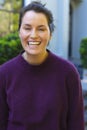 Portrait of happy caucasian woman standing and smiling in front of house in garden Royalty Free Stock Photo