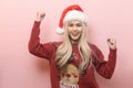 Portrait of happy Caucasian young woman in santa claus hat over pink background Royalty Free Stock Photo