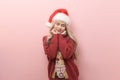 Portrait of happy Caucasian young woman in santa claus hat over pink background Royalty Free Stock Photo