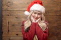 Portrait of happy Caucasian young woman in santa claus hat over wooden background Royalty Free Stock Photo
