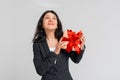 Portrait of happy charismatic brunette teenager girl in black blazer holding gift box wondering whats inside as celebrating Royalty Free Stock Photo